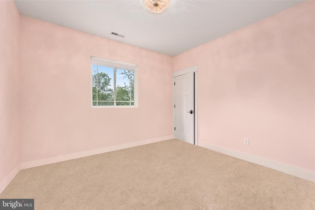 unfurnished room featuring carpet floors, visible vents, and baseboards