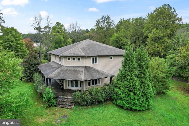 exterior space with a shingled roof and a yard