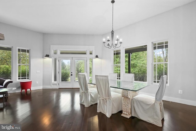 dining space with baseboards, french doors, hardwood / wood-style flooring, and a notable chandelier