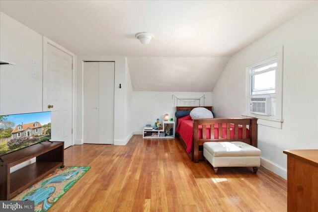 bedroom featuring baseboards, lofted ceiling, wood finished floors, and cooling unit