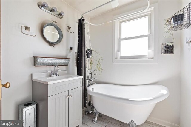 full bathroom featuring a shower with curtain, a freestanding bath, and vanity