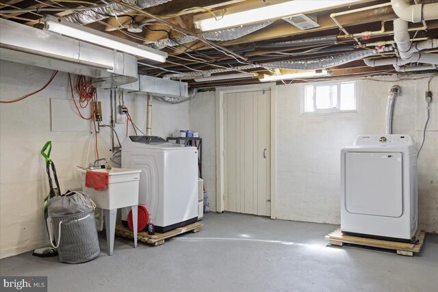 basement with a sink and washing machine and clothes dryer
