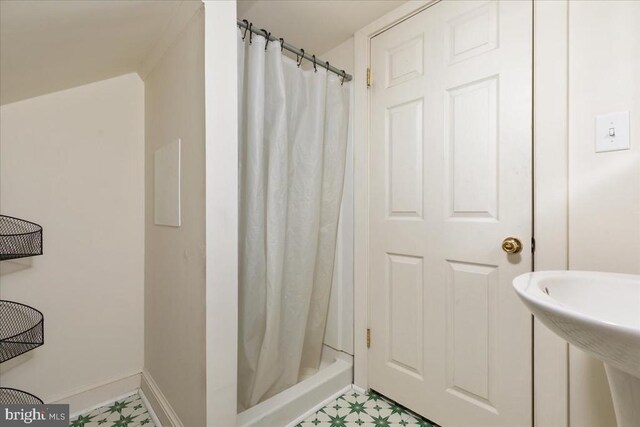 full bathroom with a shower with curtain, tile patterned floors, and baseboards
