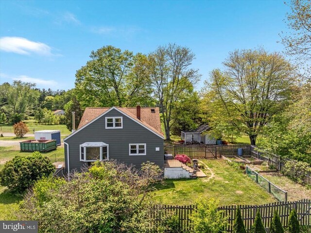 rear view of property with a lawn, a fenced backyard, and a chimney