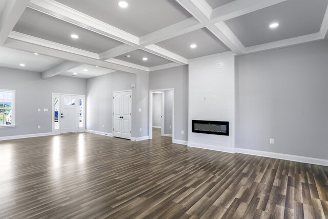 unfurnished living room featuring dark hardwood / wood-style floors, a large fireplace, coffered ceiling, and beam ceiling