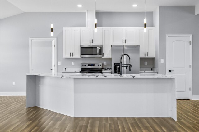 kitchen featuring white cabinetry, hanging light fixtures, stainless steel appliances, and an island with sink