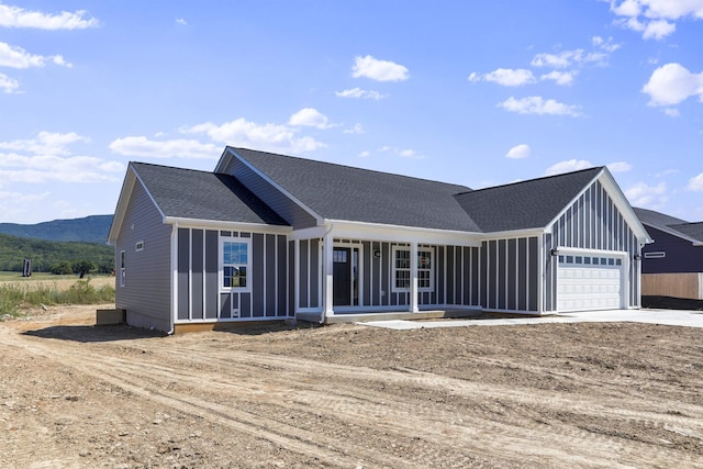 view of front facade featuring a mountain view, a garage, and covered porch