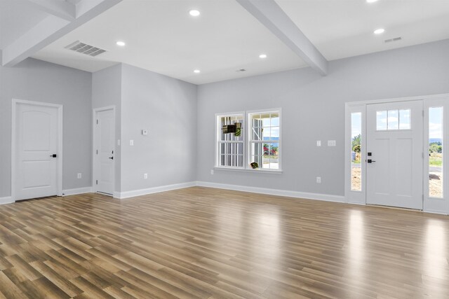 entrance foyer featuring plenty of natural light, hardwood / wood-style floors, and beam ceiling