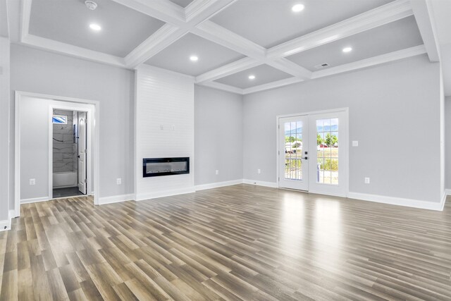 unfurnished living room featuring beam ceiling, hardwood / wood-style flooring, and coffered ceiling