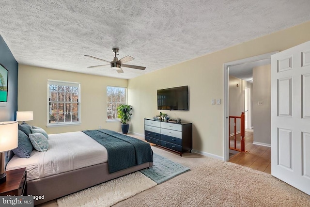 bedroom with baseboards, carpet, a ceiling fan, and a textured ceiling