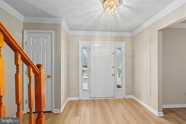 foyer with stairway, baseboards, light wood-style floors, and ornamental molding