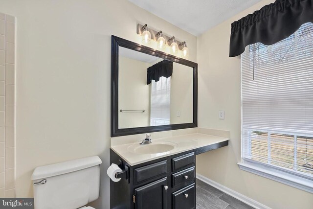 bathroom featuring vanity, toilet, and baseboards