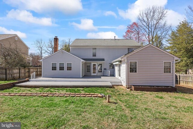 rear view of property featuring a yard, a fenced backyard, french doors, and a wooden deck