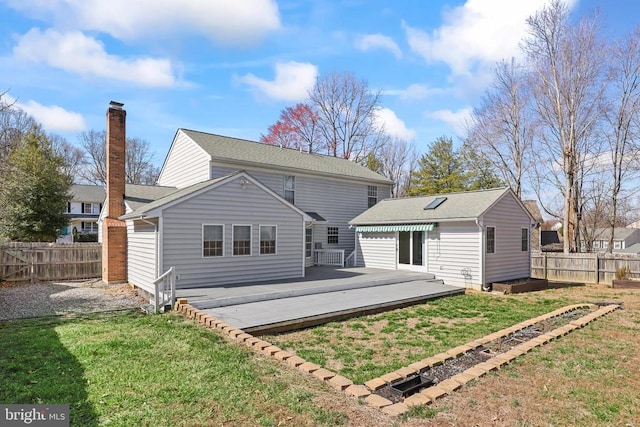 rear view of property featuring a wooden deck, a yard, and fence