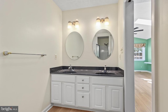 bathroom featuring double vanity, wood finished floors, and a sink