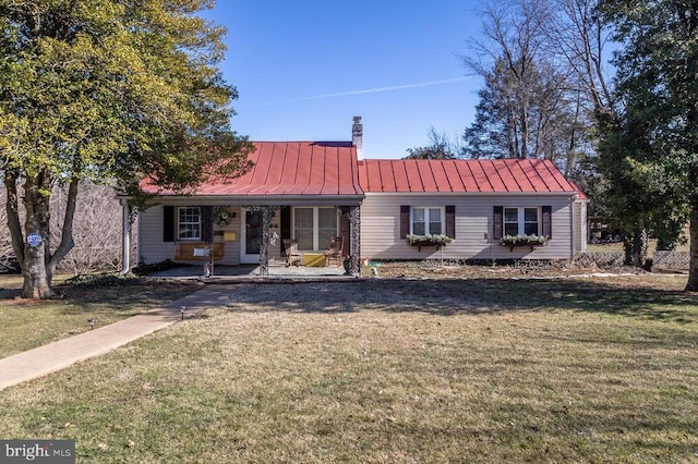 view of front of home featuring a front yard, a standing seam roof, and covered porch