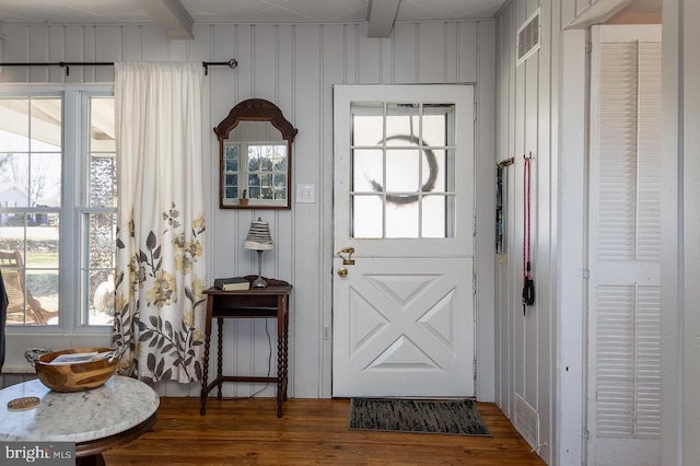 entryway with dark wood-type flooring, visible vents, and beam ceiling