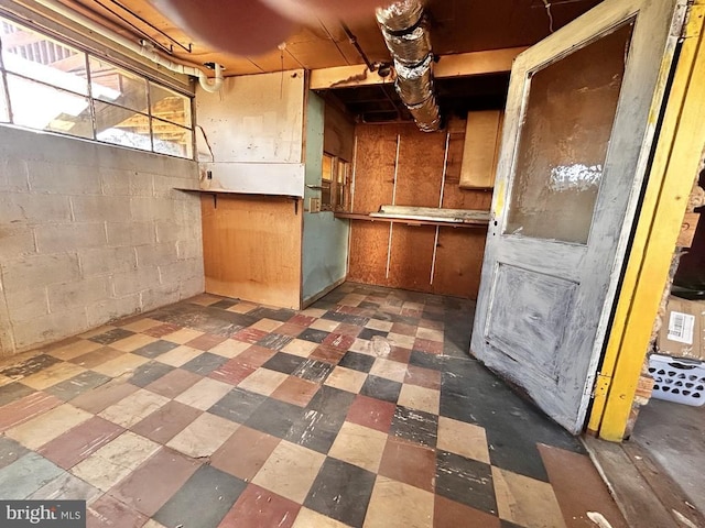 kitchen featuring concrete block wall and tile patterned floors