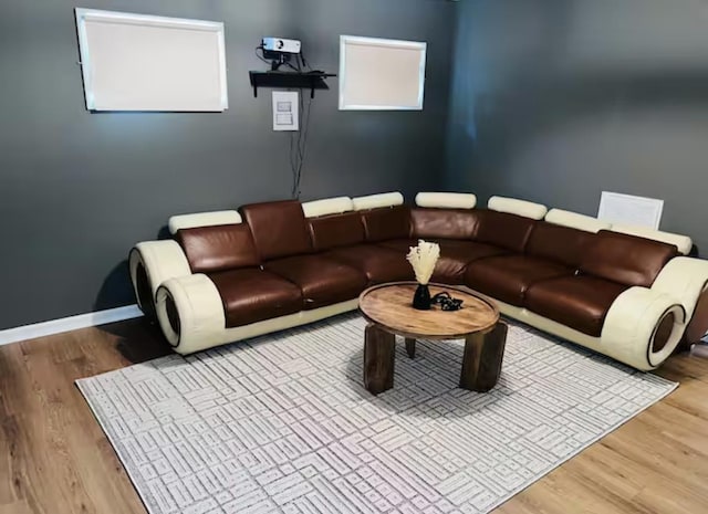 living area with baseboards and wood finished floors