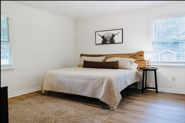 bedroom featuring baseboards and wood finished floors