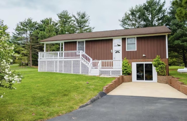 view of front facade featuring board and batten siding, a front lawn, and brick siding
