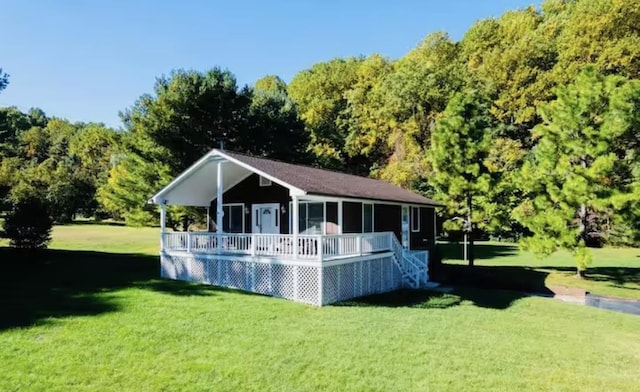 rear view of house with a yard and a wooded view