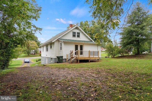 back of property featuring a wooden deck, a yard, and french doors