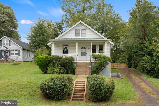 bungalow-style home featuring a front yard and covered porch