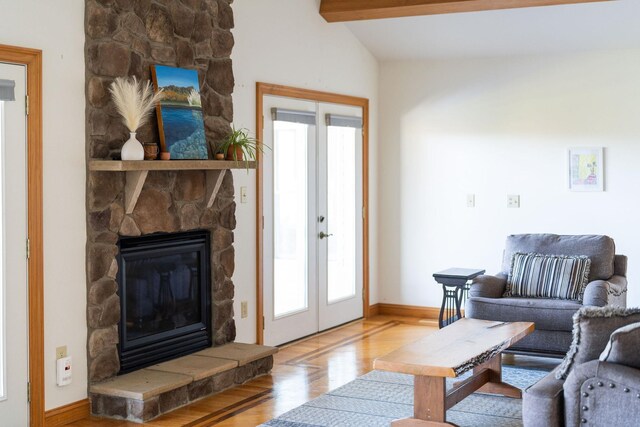 living room featuring hardwood / wood-style flooring, lofted ceiling with beams, a healthy amount of sunlight, and french doors