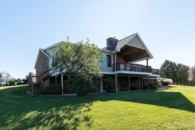 rear view of property featuring a yard, ceiling fan, and a deck