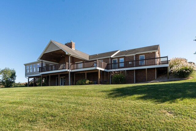 rear view of property with a deck and a lawn