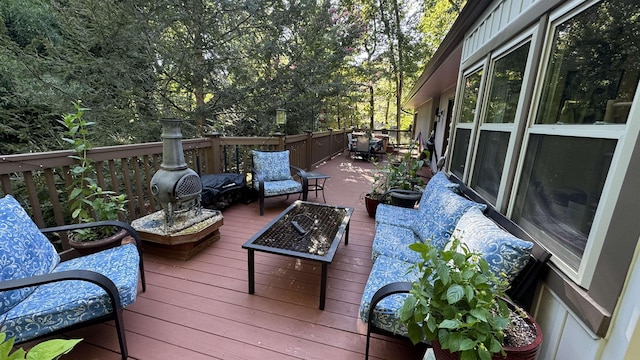 deck with an outdoor living space with a fire pit