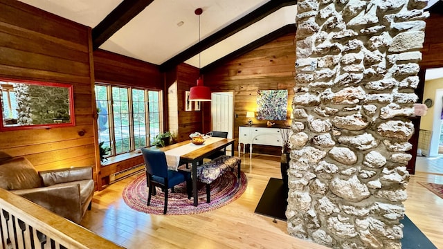 dining space with high vaulted ceiling, hardwood / wood-style flooring, a baseboard radiator, wooden walls, and beamed ceiling