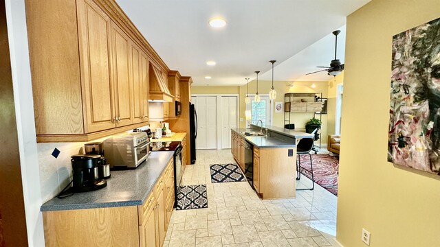 kitchen featuring a kitchen bar, a center island with sink, pendant lighting, ceiling fan, and black appliances