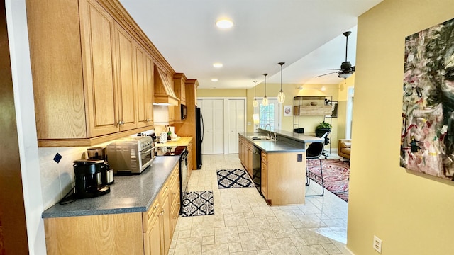 kitchen featuring a kitchen bar, a center island with sink, pendant lighting, ceiling fan, and black appliances