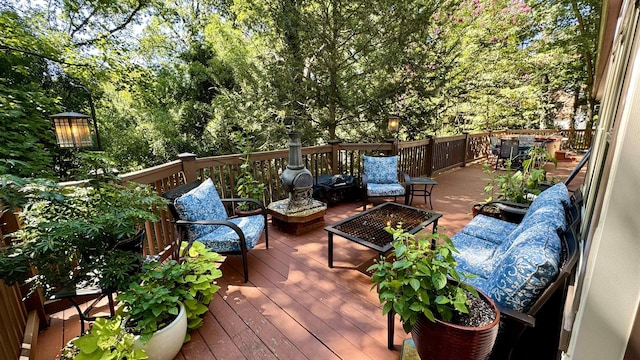 deck with an outdoor living space with a fire pit