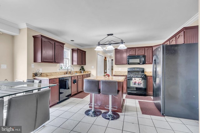 kitchen with a center island, pendant lighting, light tile patterned floors, and black appliances