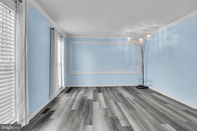 empty room with ornamental molding, wood-type flooring, and a notable chandelier