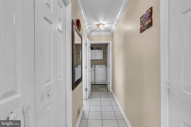 hall featuring separate washer and dryer, light tile patterned floors, and ornamental molding