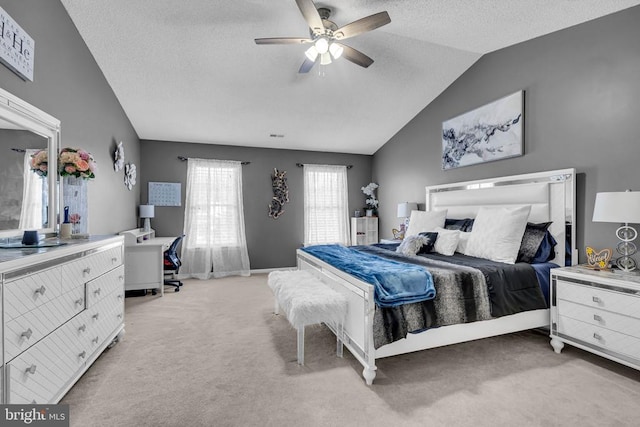 carpeted bedroom featuring a textured ceiling, vaulted ceiling, and ceiling fan