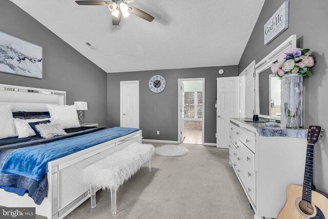 bedroom with vaulted ceiling, light colored carpet, and ceiling fan