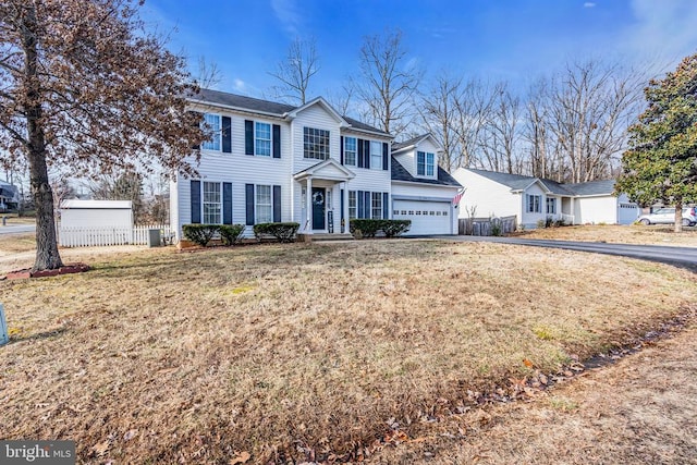 view of front of property featuring cooling unit, a garage, and a front yard