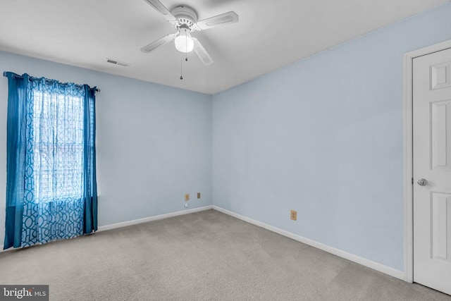 spare room featuring light carpet and ceiling fan