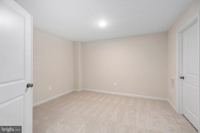 unfurnished room featuring light carpet