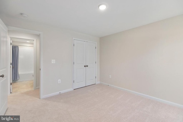 unfurnished bedroom with light colored carpet and a closet