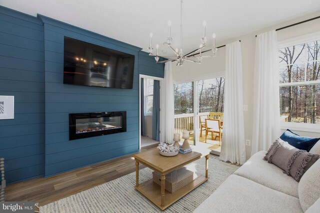 living room featuring hardwood / wood-style flooring, a large fireplace, and a chandelier