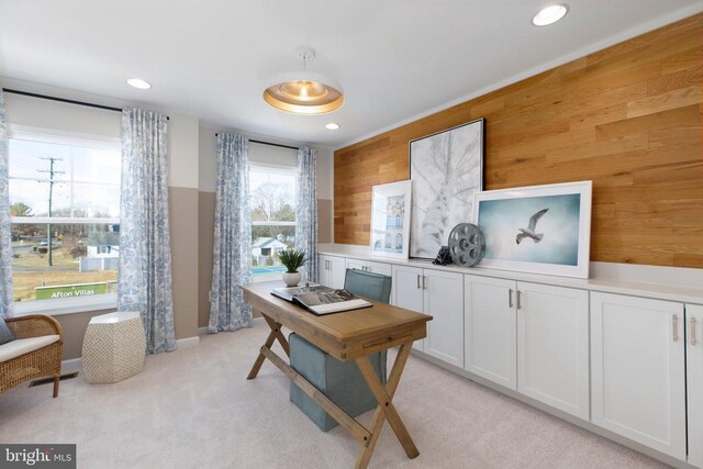 home office featuring light colored carpet and wood walls