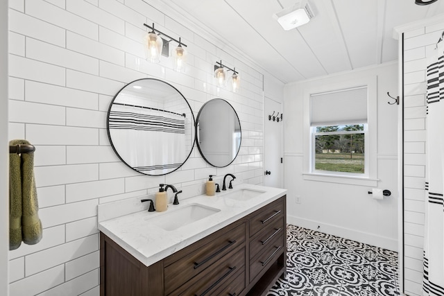 full bathroom with double vanity, baseboards, backsplash, and a sink