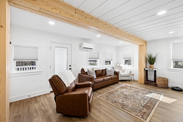 living area with beamed ceiling, a wall mounted air conditioner, baseboards, and wood finished floors