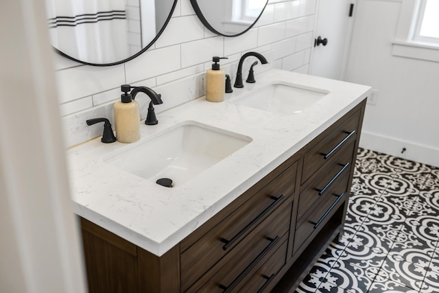 full bathroom featuring a sink, tasteful backsplash, and double vanity